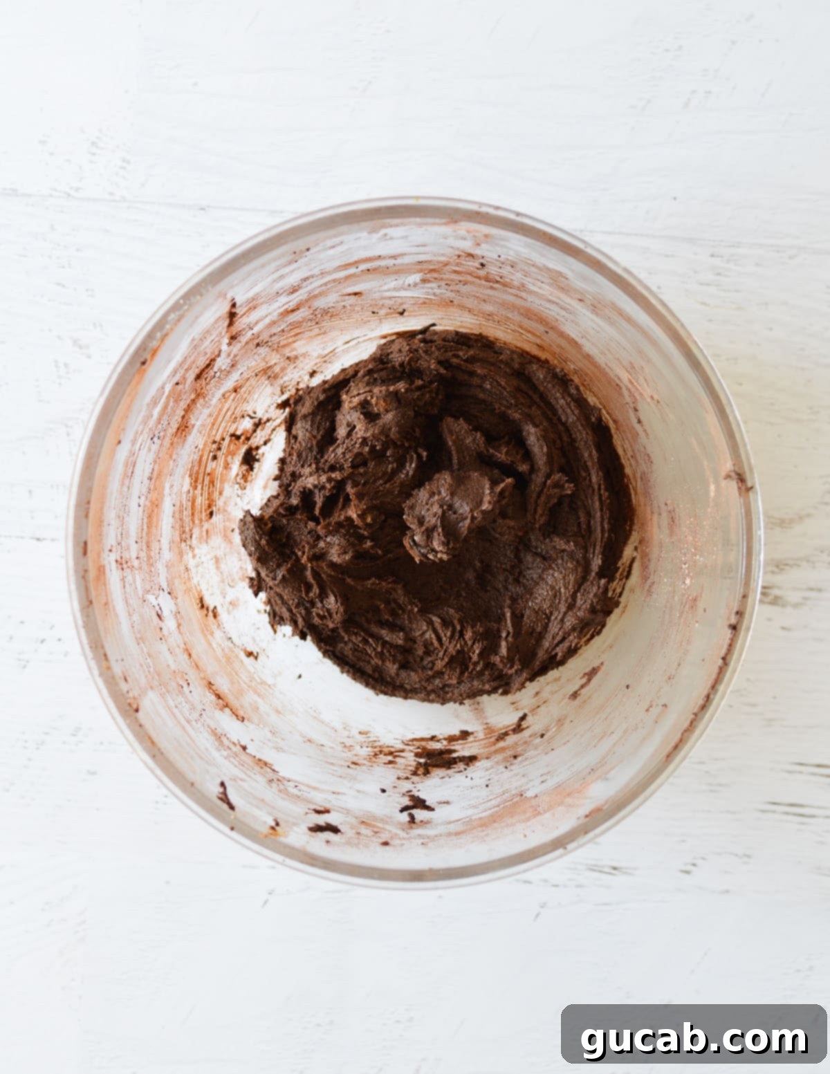 Dark, rich chocolate cookie dough formed in a bowl, ready for mix-ins.