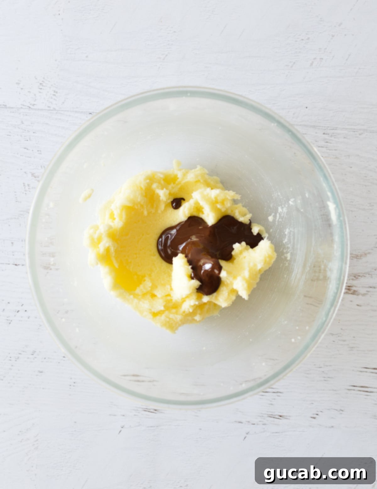 Creamed butter and sugar with melted dark chocolate added to the bowl.