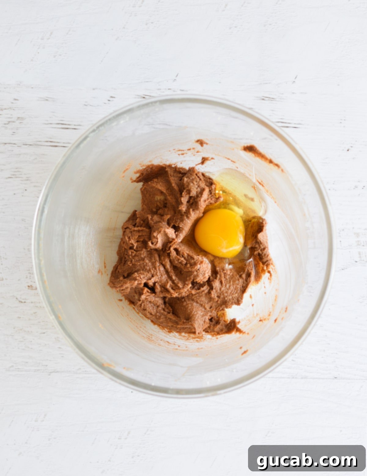 The rich chocolate mixture with a single egg on top, ready to be beaten.