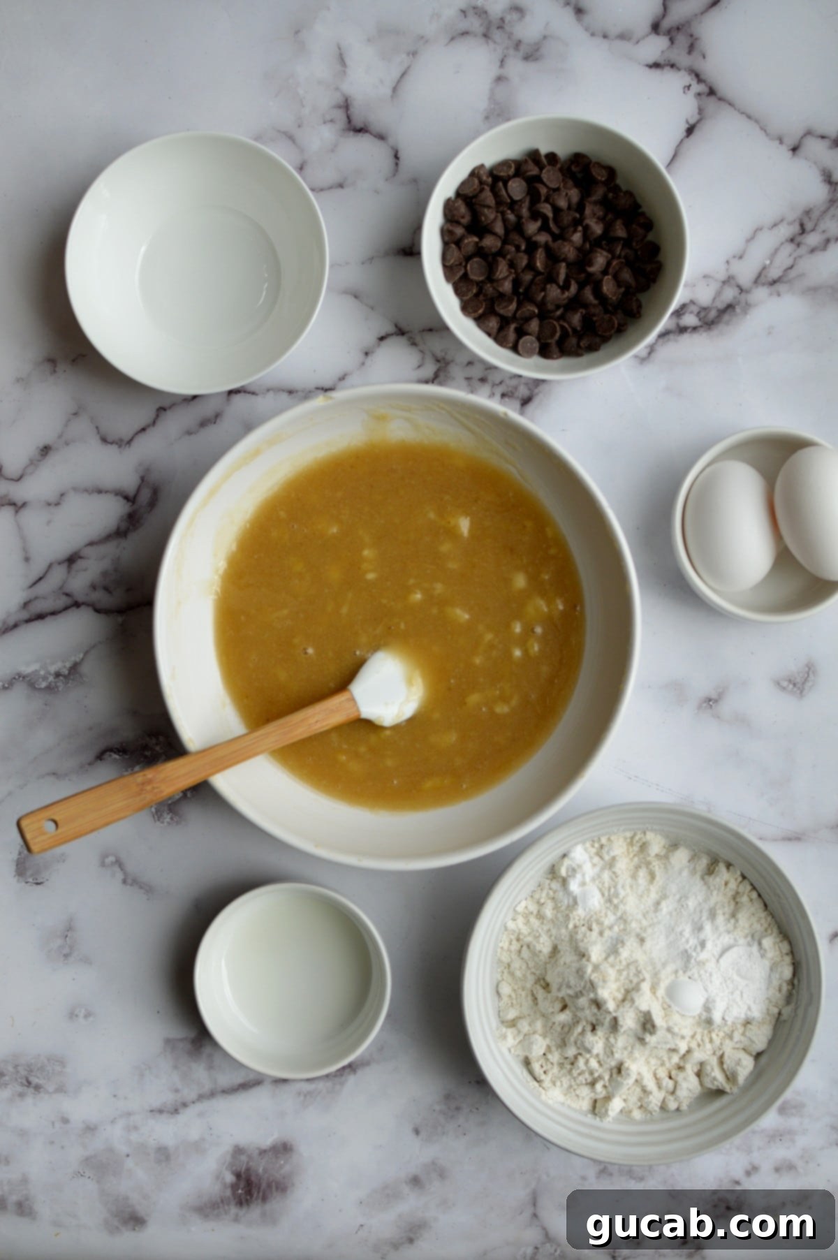 Wet ingredients (sugar, oil, and mashed banana) mixed together in a bowl