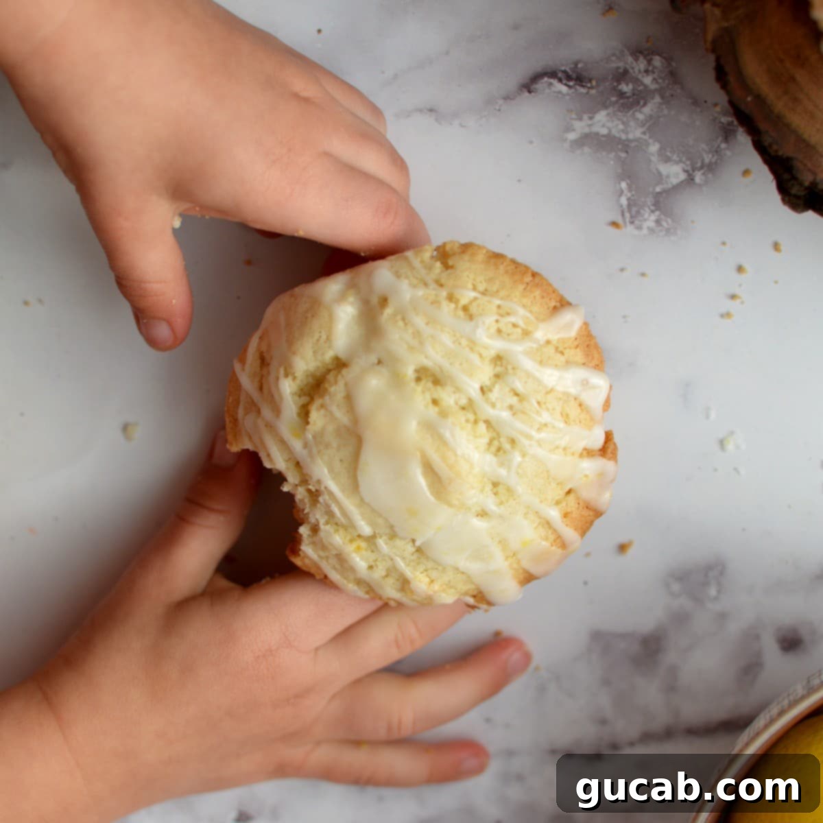 Gluten-free lemon muffin with a generous lemon drizzle, showing its light texture
