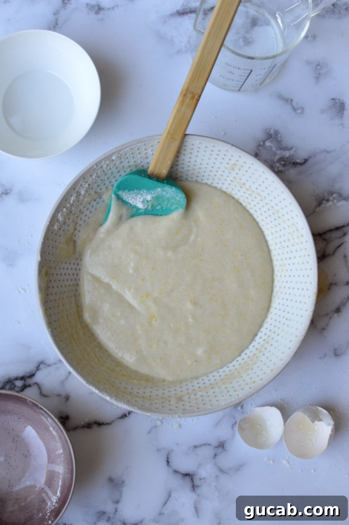Thick gluten-free lemon muffin batter in a mixing bowl