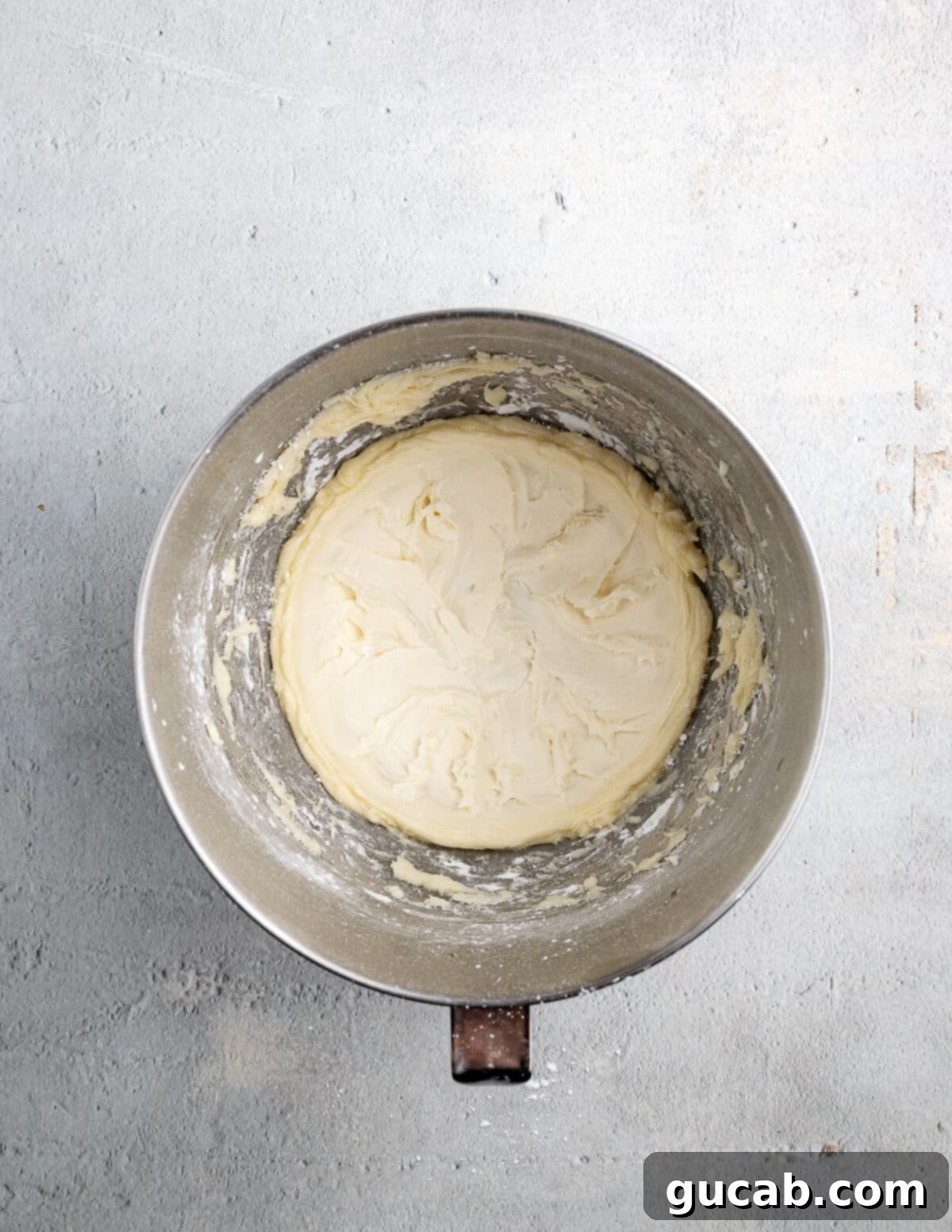 Golden Pumpkin Bliss: Gluten-Free Maple-Cinnamon Cupcakes 13 Softened butter and powdered sugar being whipped together in a stand mixer, creating a creamy base for the frosting.