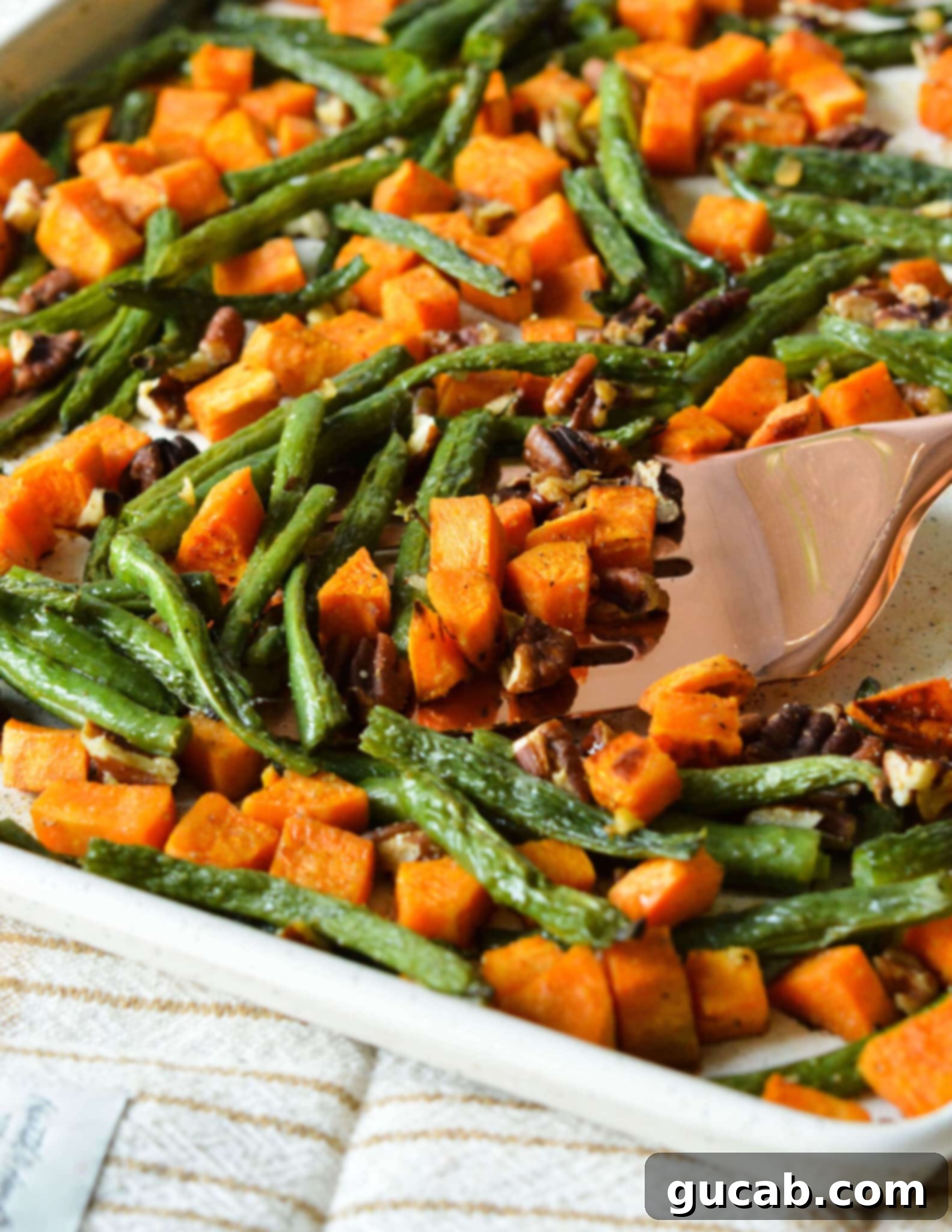 Perfectly Roasted Green Beans and Sweet Potatoes 2 Roasted green beans, sweet potatoes, and pecans on a sheet pan, ready to serve.
