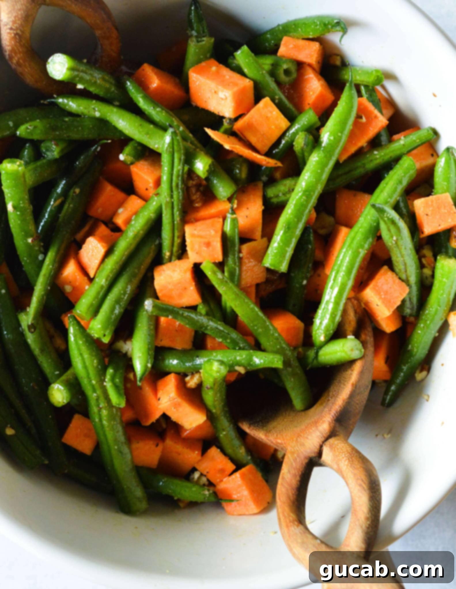 Perfectly Roasted Green Beans and Sweet Potatoes 7 Sweet potatoes and green beans in a bowl, glistening with olive oil and spices after being thoroughly tossed.