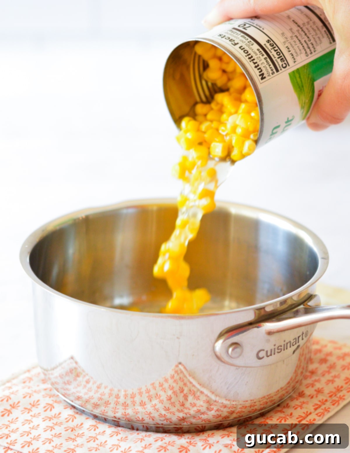 pouring a can of corn into a saucepan.