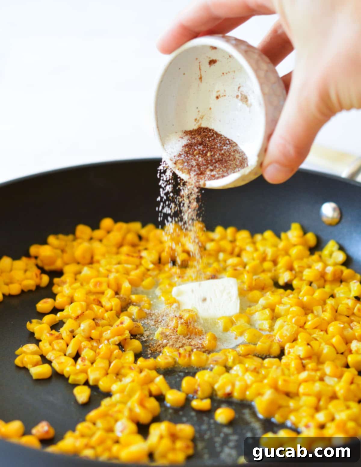 corn in a skillet with butter and spices.