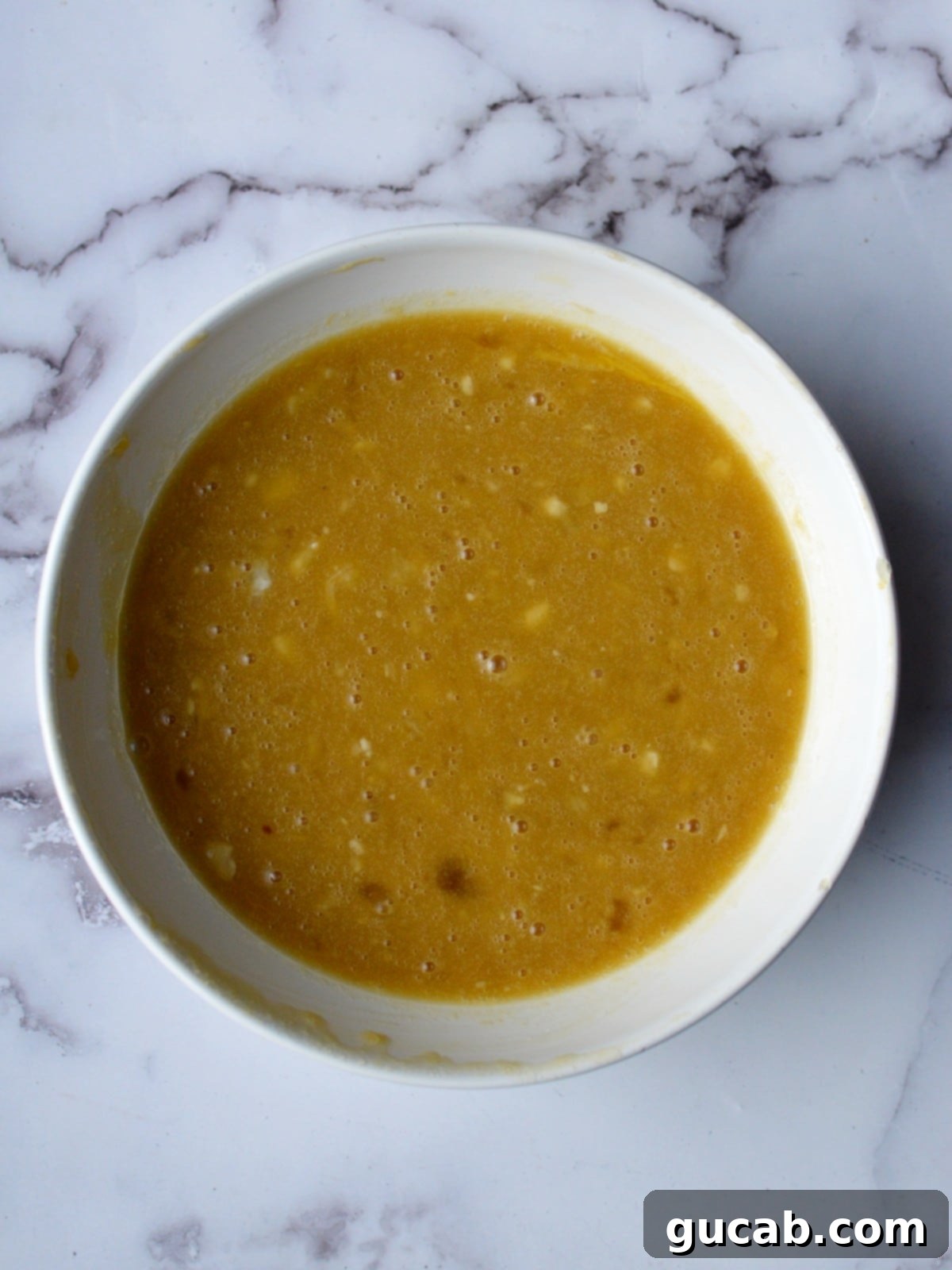 a bowl of banana, eggs, and sugar mixture