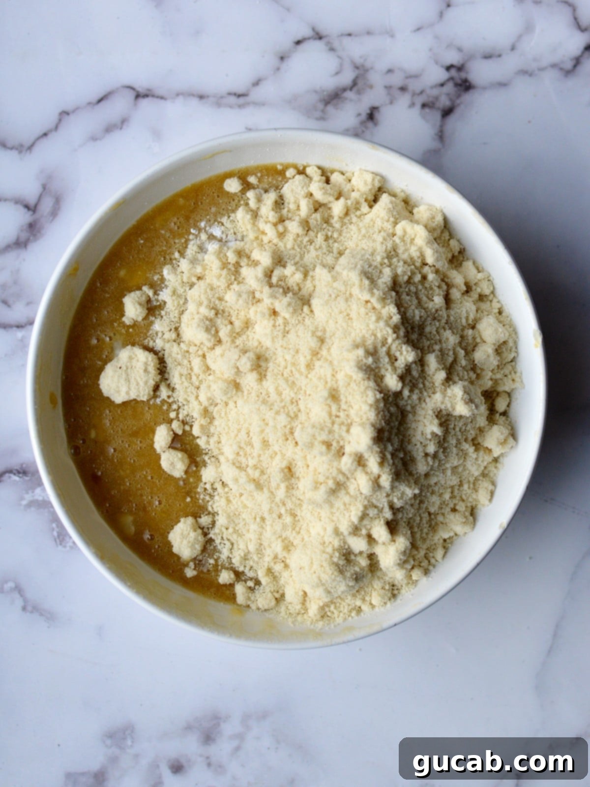 almond flour being added to eggs and mashed banana mixture
