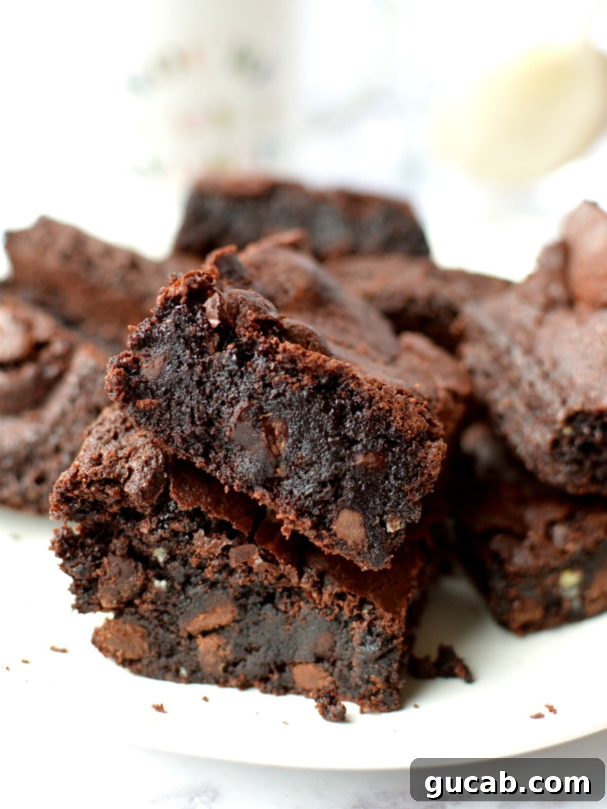 A stack of perfectly fudgy almond flour brownies, showcasing their rich color and crackled tops.