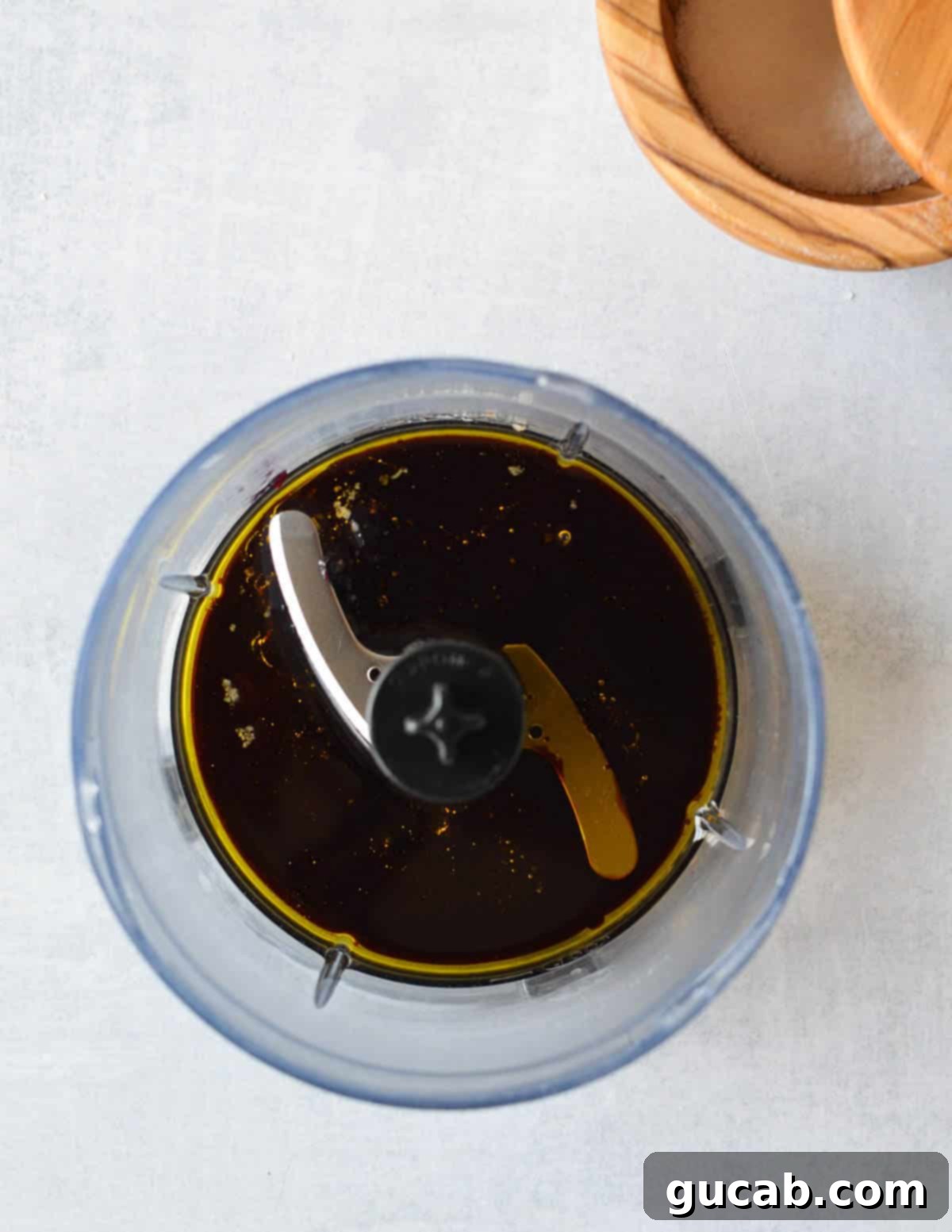 a food processor with olive oil, balsamic, and jam in it.