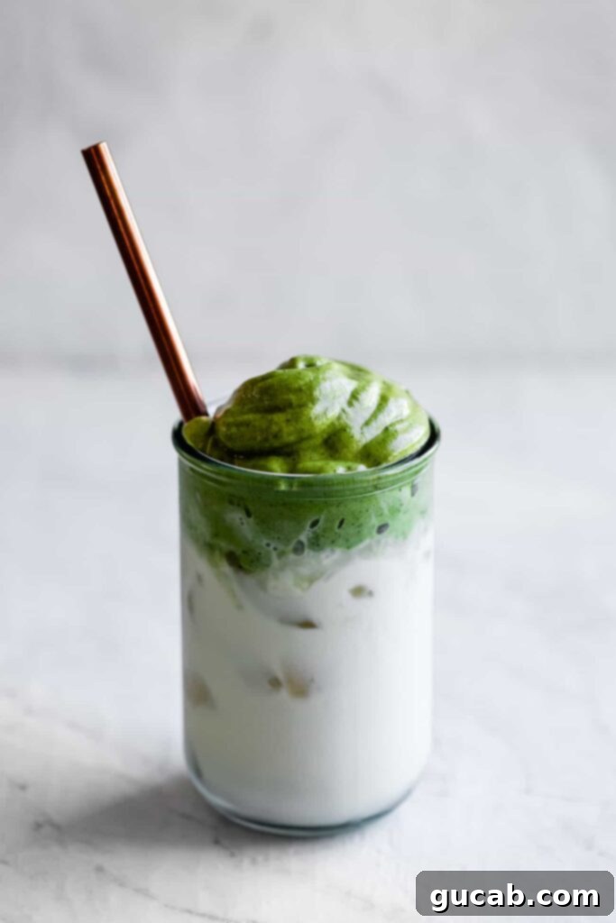 A glass of whipped matcha drink, topped with creamy foam, offering a healthier twist on a classic.