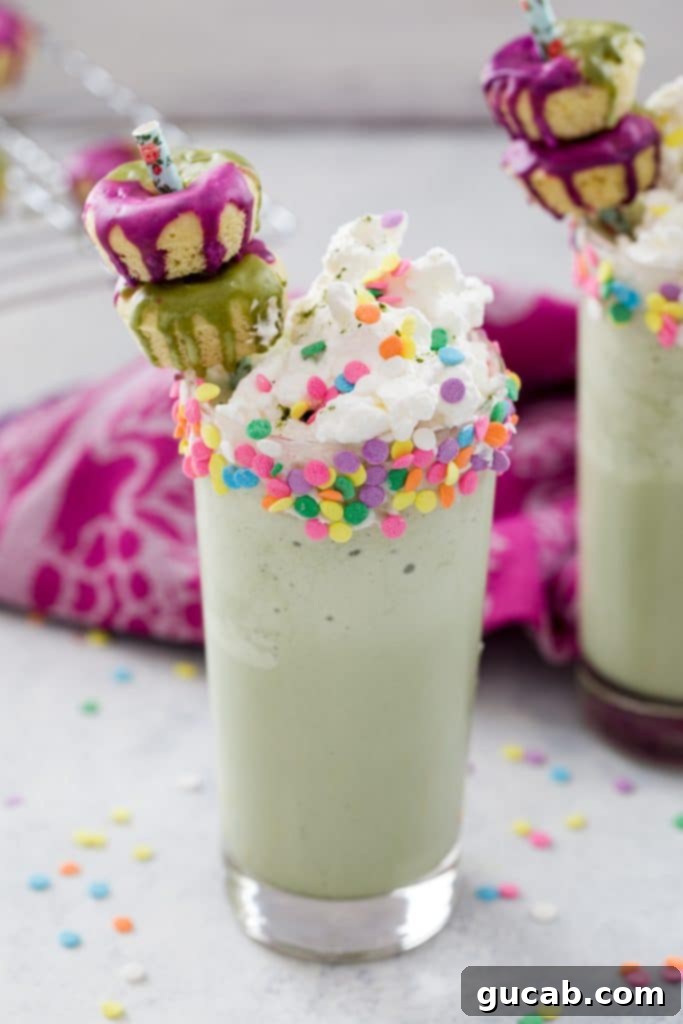 A creamy matcha milkshake topped with a generous swirl of whipped cream, inviting indulgence.
