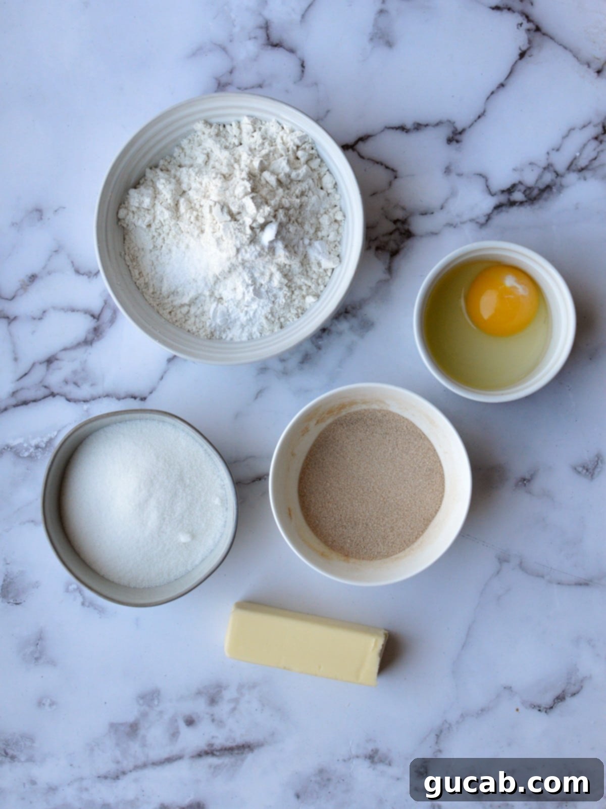 A collection of ingredients for gluten-free snickerdoodles, including flour, butter, sugar, eggs, and spices