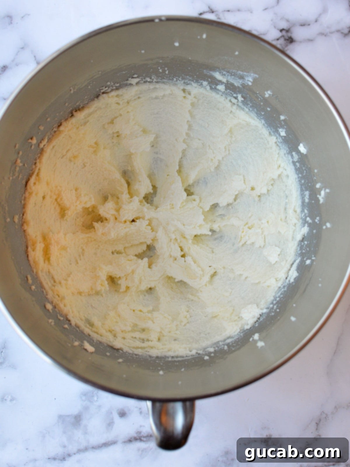 Close-up of butter and sugar creamed together in a mixer bowl until light and fluffy