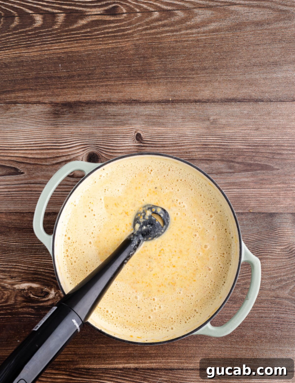 blending potato soup with an immersion blender in a dutch oven. 