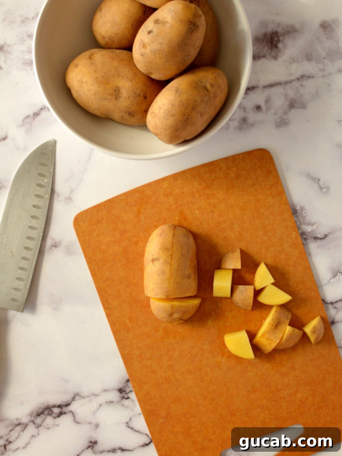 Creamy Almond Mashed Potatoes 4 a gold potato on a cutting board