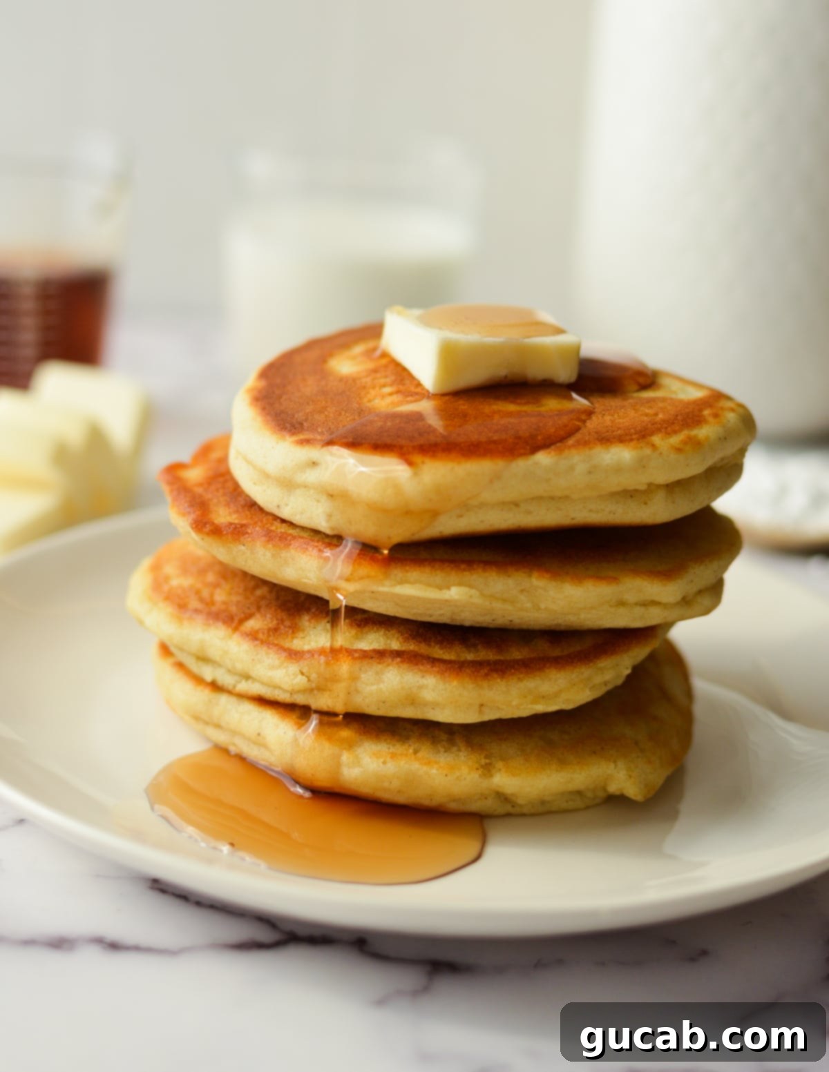 A tall stack of golden brown gluten-free pancakes, perfectly fluffy and ready to be drizzled with syrup.