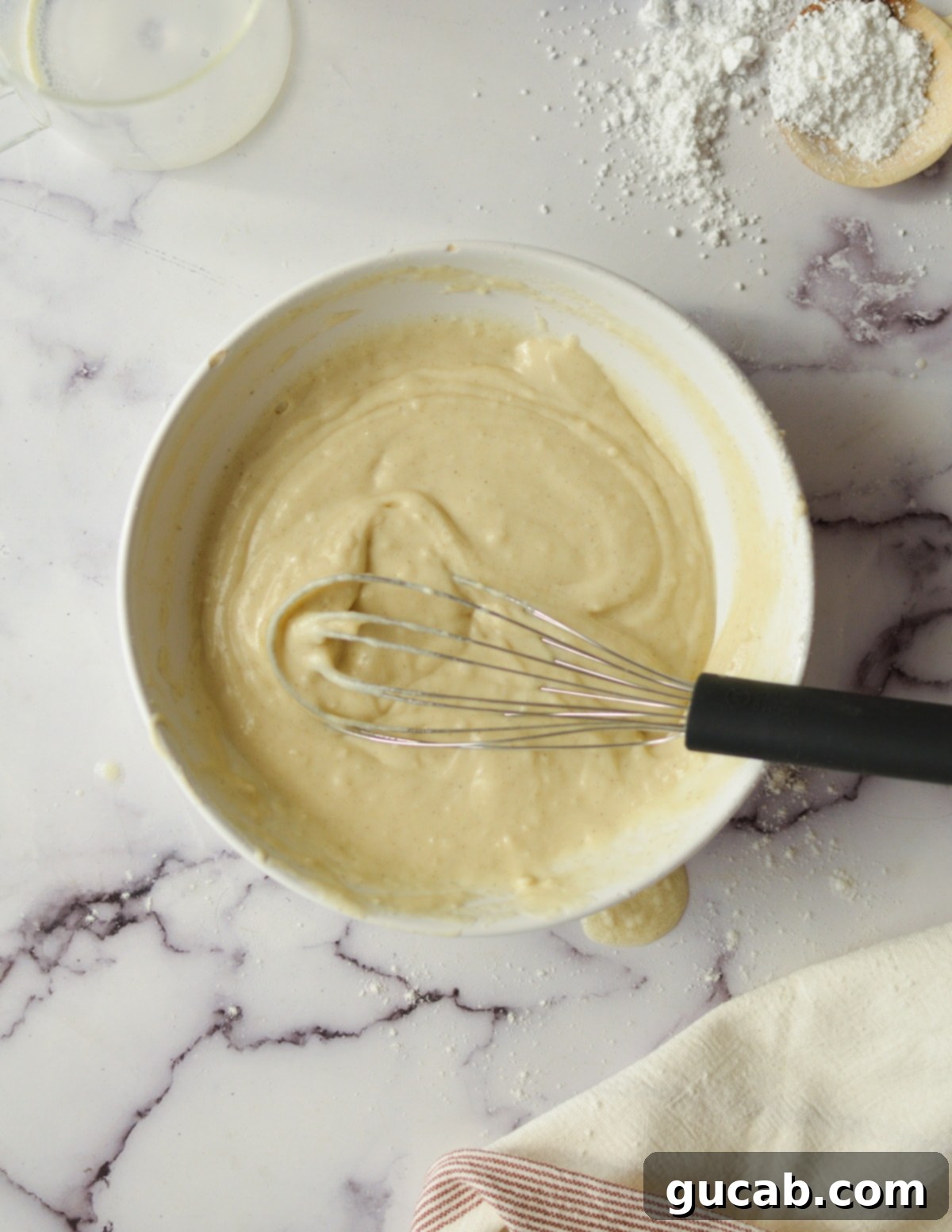 A bowl filled with gluten-free pancake batter, showing a smooth, thick consistency.