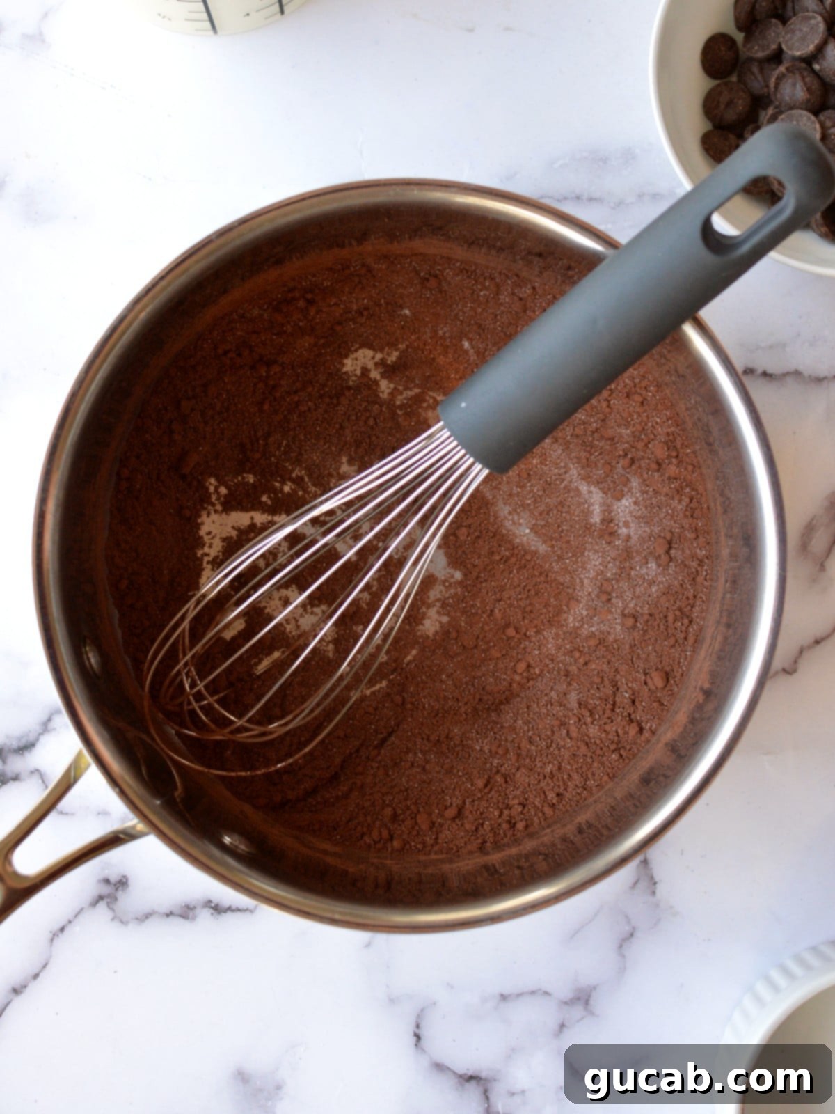 Velvety Oat Milk Hot Chocolate 4 Cocoa powder and sugar being whisked together in a saucepan, the first step in making oat milk hot chocolate