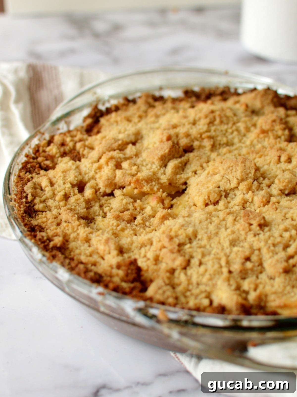 A slice of graham cracker apple pie with crumb topping, showcasing the tender apple filling and crunchy streusel, ready to be enjoyed.