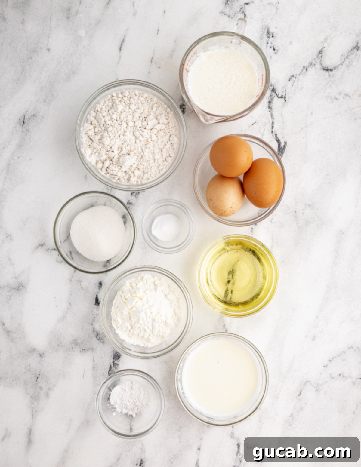 Your New Favorite Gluten-Free Waffle Recipe 3 A collection of essential ingredients for gluten-free waffles laid out: gluten-free flour, milk, sugar, oil, eggs, buttermilk, baking powder, baking soda, and kosher salt.