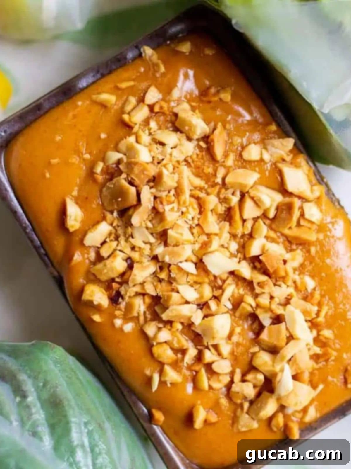 a container of peanut sauce with chopped peanuts