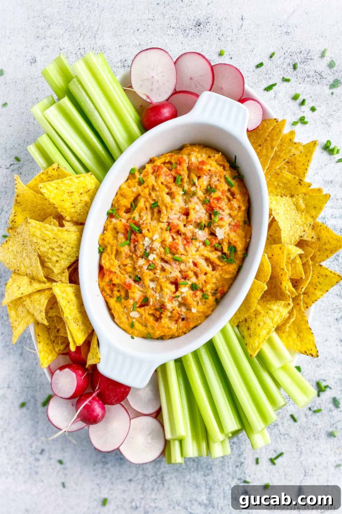 a ramekin of vegan buffalo dip and tortilla chips