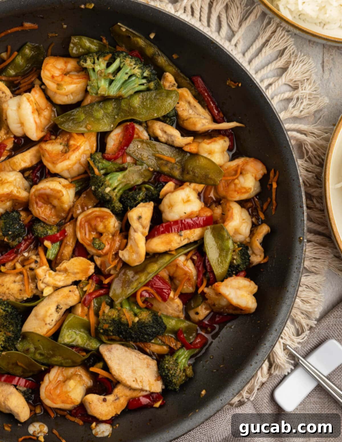 A large nonstick skillet filled to the brim with the glorious chicken and shrimp stir fry, showcasing all the ingredients perfectly cooked and coated in the rich sauce, ready to be served.