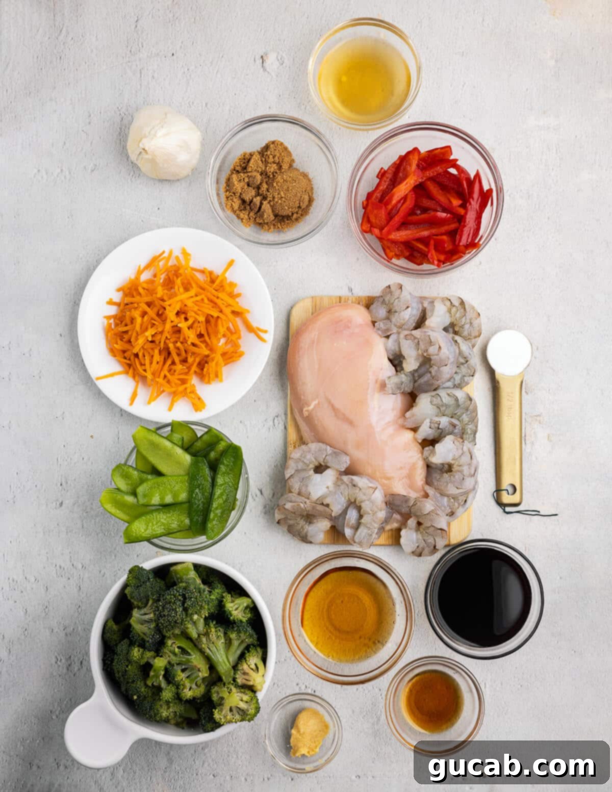 An array of stir fry sauce ingredients, including soy sauce, garlic, chicken broth, brown sugar, and sesame oil, neatly arranged in a liquid measuring cup, ready for whisking.