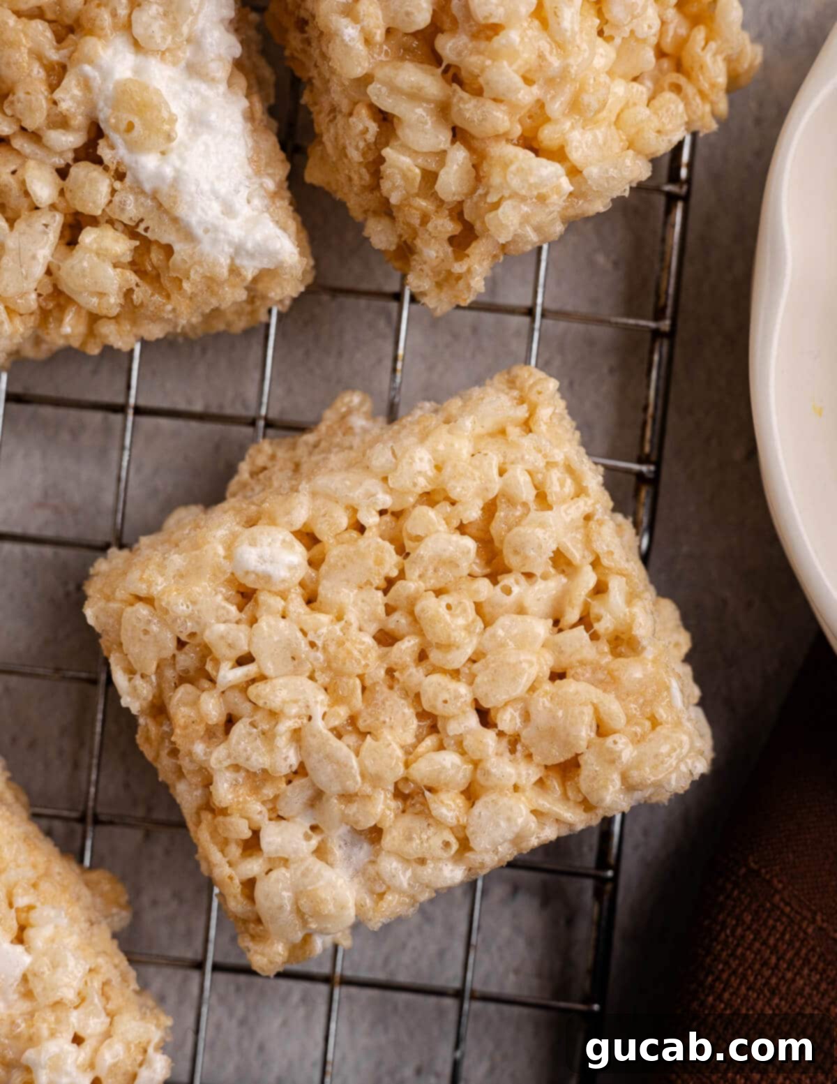 A single homemade rice krispie bar resting on a wire rack, showcasing its golden perfection.