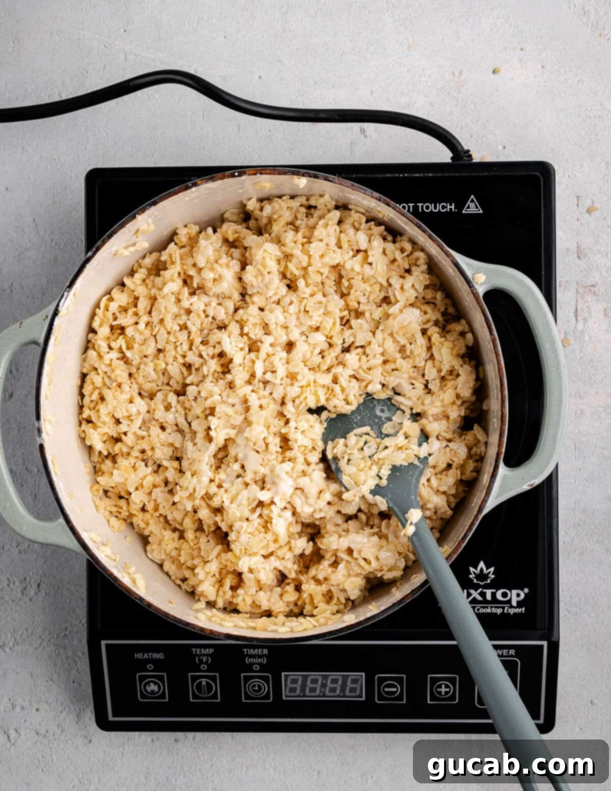 A dutch oven with rice krispies cereal fully coated in the gooey marshmallow mixture.