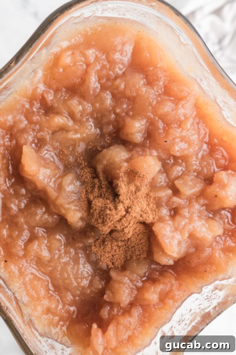 Smooth, cooked applesauce swirling in a high-speed blender, with a sprinkle of cinnamon on top.
