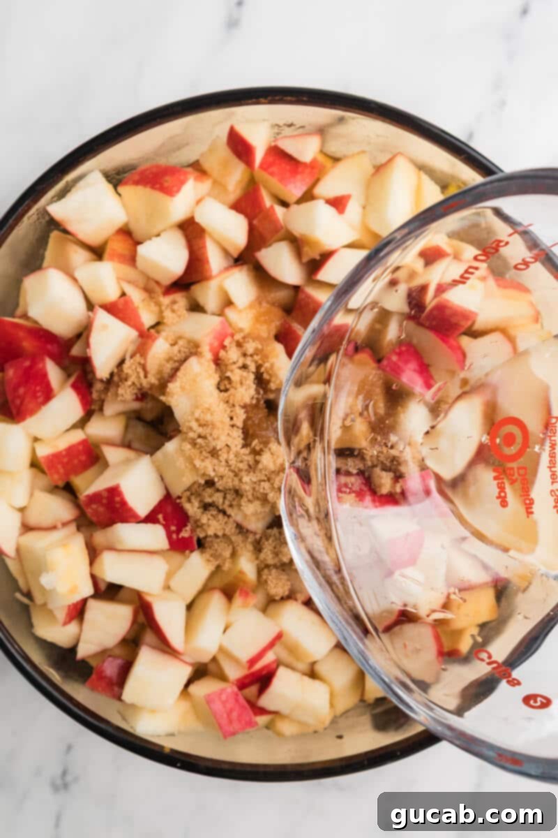 A steady stream of water being poured into a pot filled with chopped apples and brown sugar.