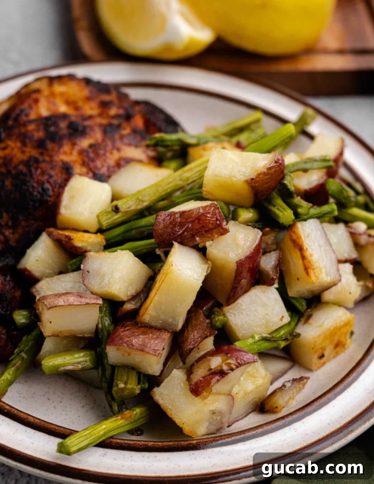 A vibrant plate featuring perfectly roasted chicken, alongside golden-brown, crispy red potatoes and tender green asparagus spears.
