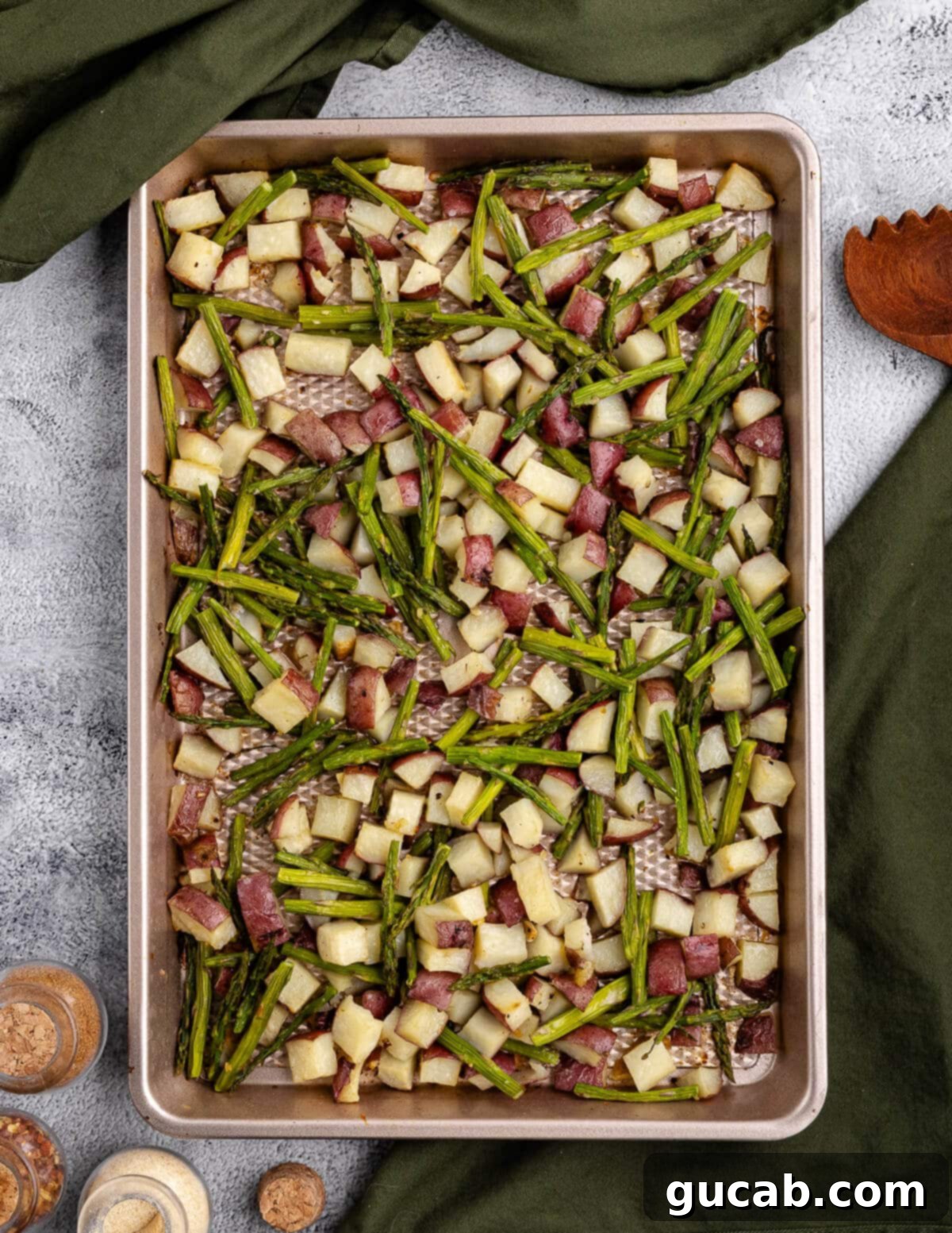 A close-up of a full sheet pan of perfectly golden, crispy roasted potatoes and tender, slightly charred asparagus, fresh out of the oven.