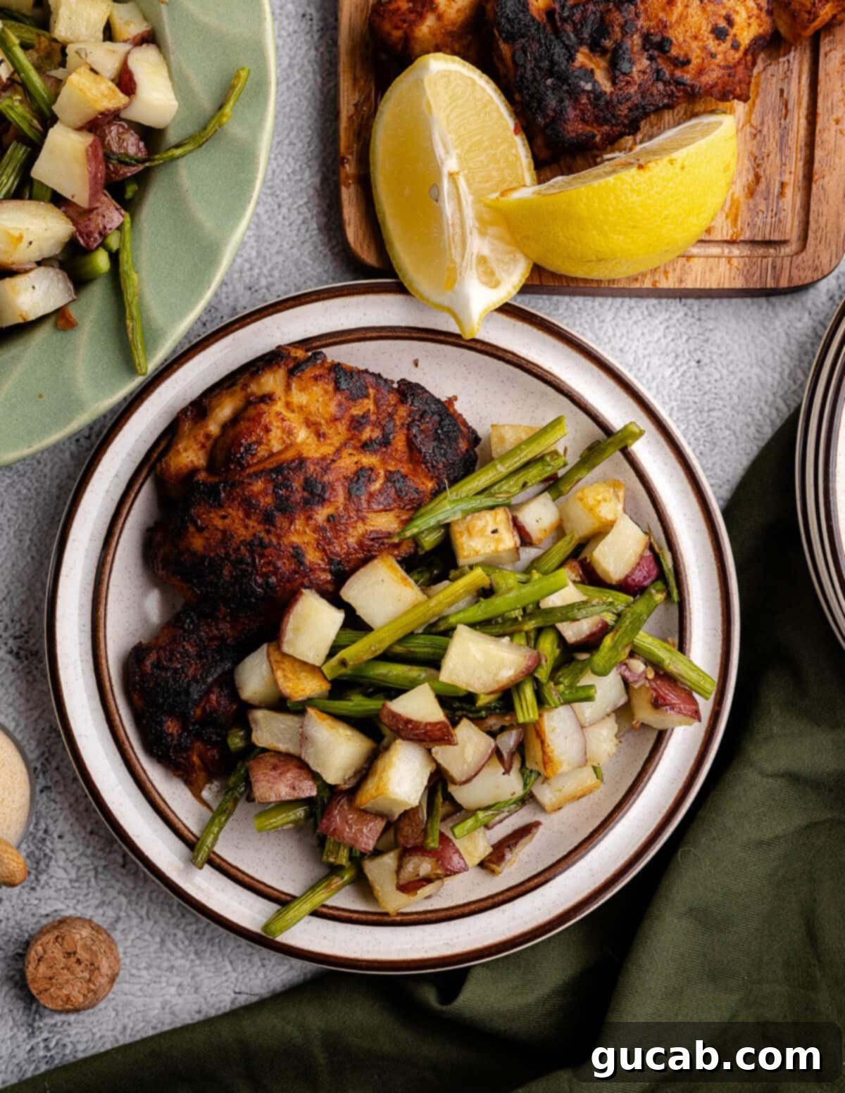 A beautifully plated dinner featuring roasted chicken, a generous serving of roasted potatoes and asparagus, ready to be enjoyed.