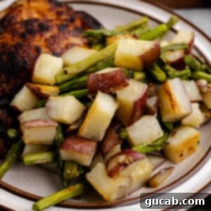 A plate of roasted potatoes and asparagus, showcasing the golden-brown potatoes and tender green asparagus, ready to be served.