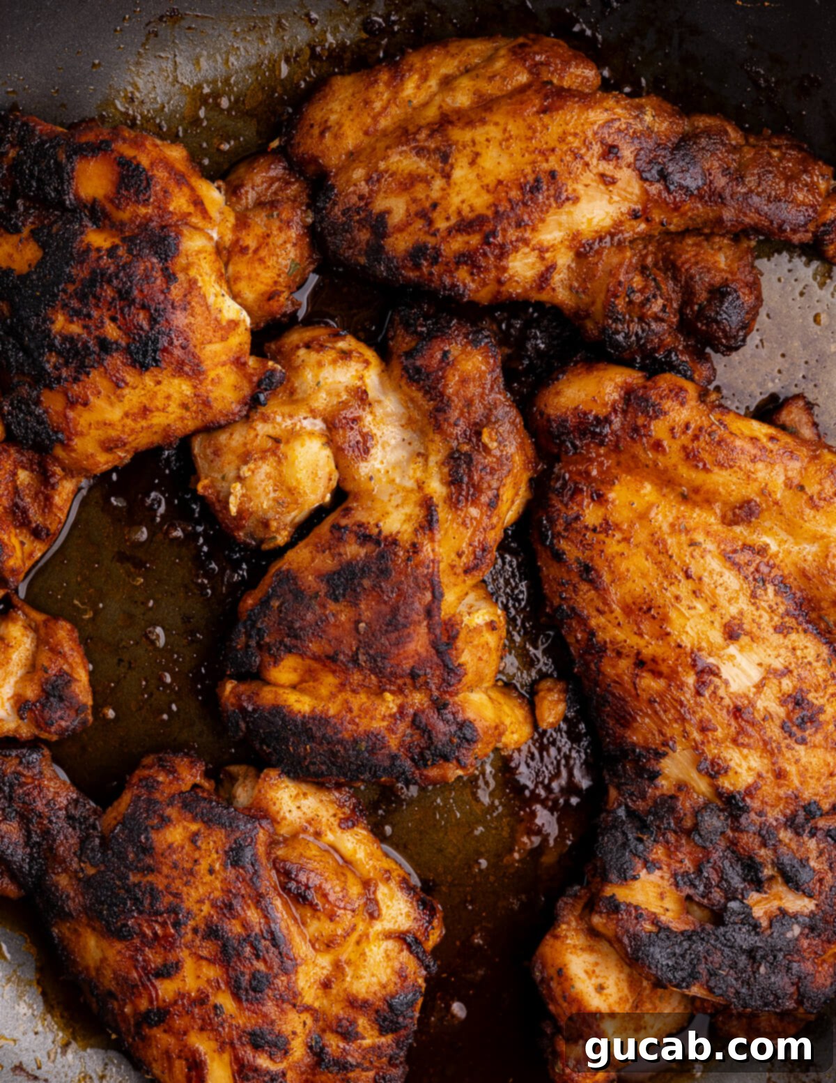 Perfectly Baked Boneless Skinless Chicken Thighs 9 caramelized chicken thighs in a skillet.