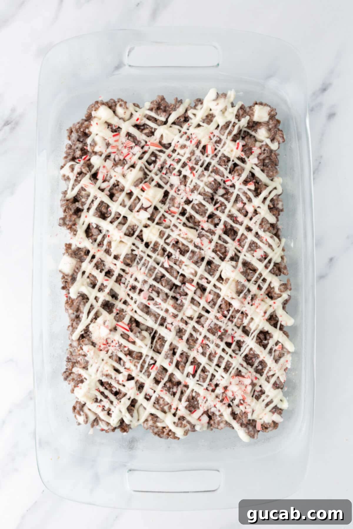 White chocolate and peppermint candies on top of cocoa Rice Krispie treats