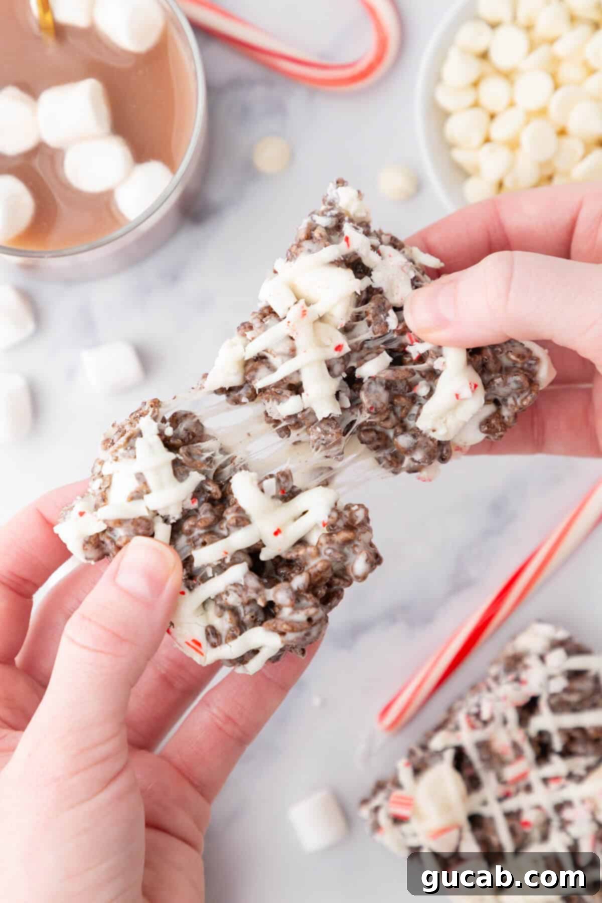 Hands pulling apart a peppermint Rice Krispie treat
