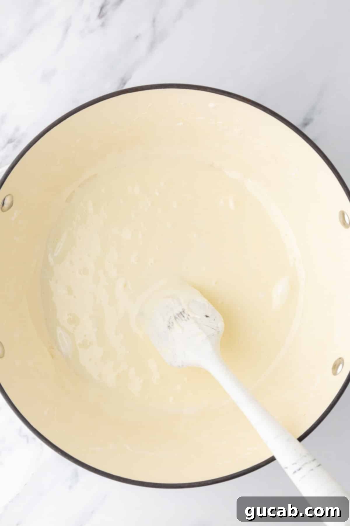 Melted marshmallow and butter in a Dutch oven with a spatula