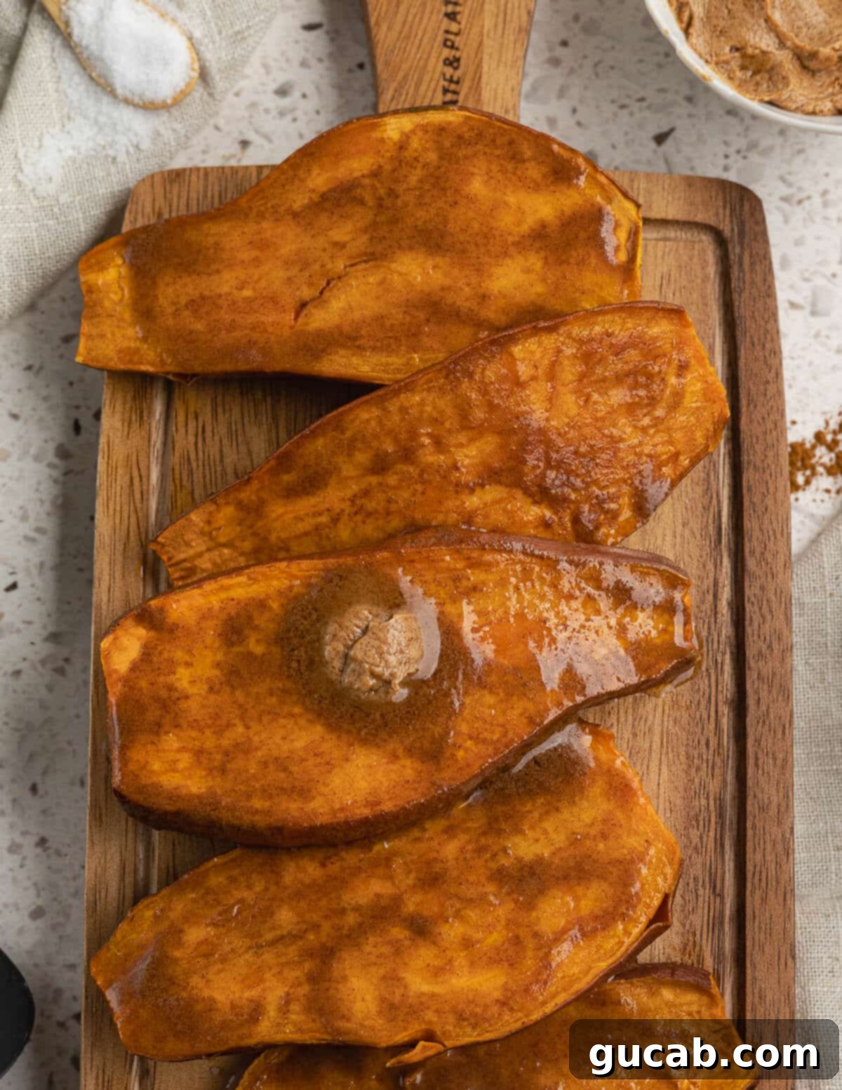 The final product: perfectly baked sweet potatoes topped with a generous swirl of cinnamon maple butter, ready to be enjoyed.