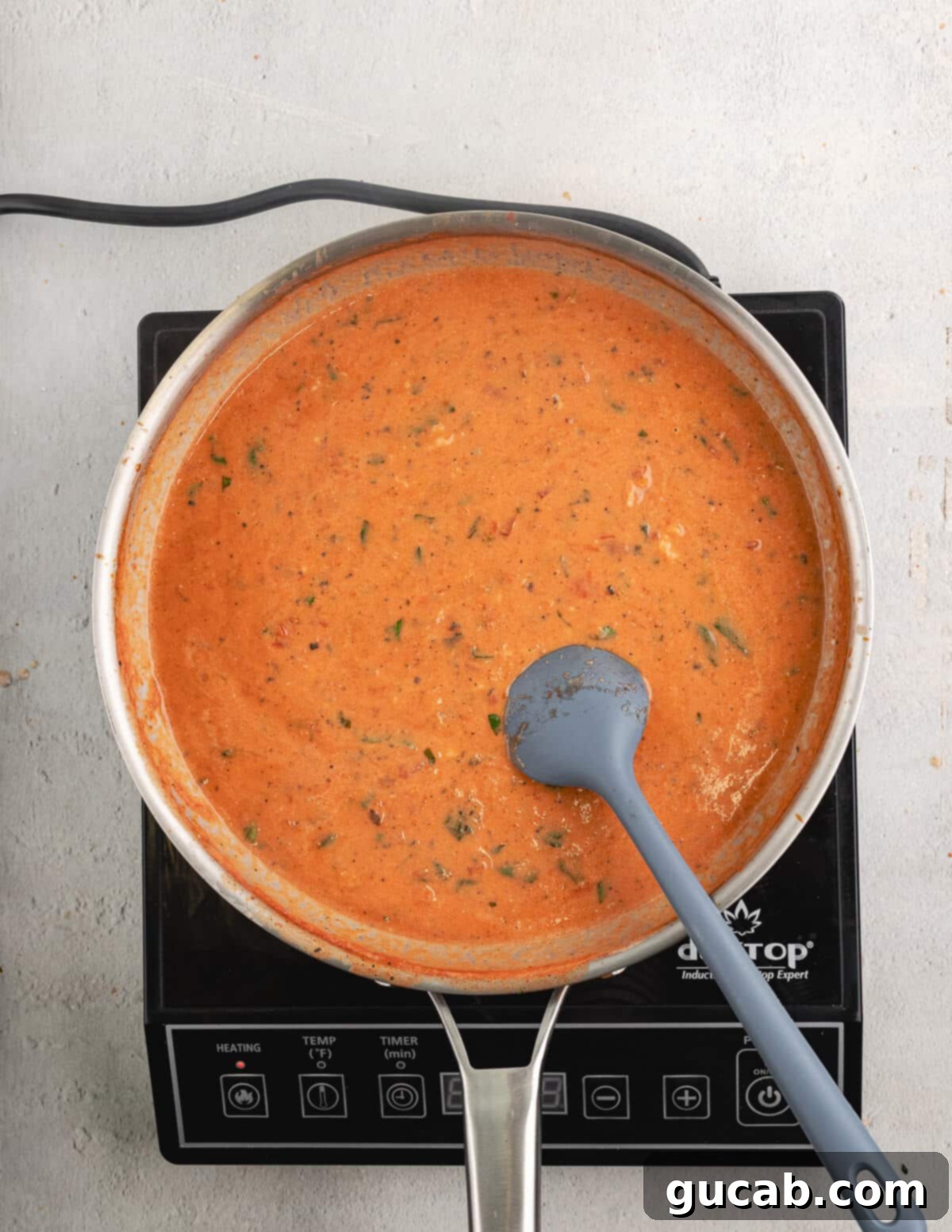 A rich and creamy vodka sauce simmering in a skillet.