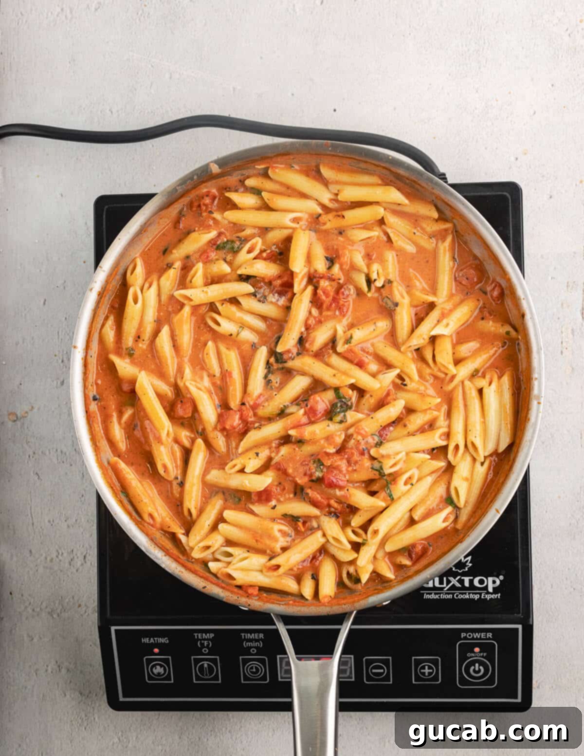 Perfectly combined pasta and vodka sauce in a skillet.