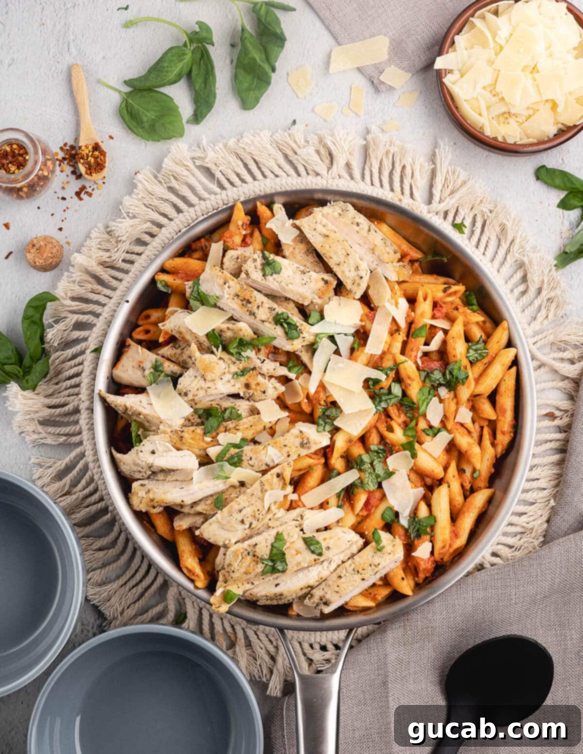 A steaming skillet of vodka pasta with perfectly sliced chicken.