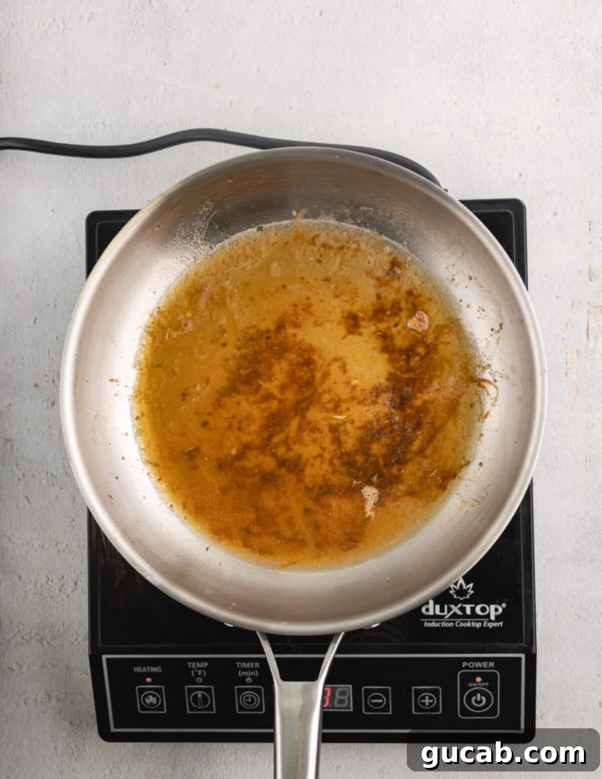 Deglazing a skillet with flavorful chicken stock.