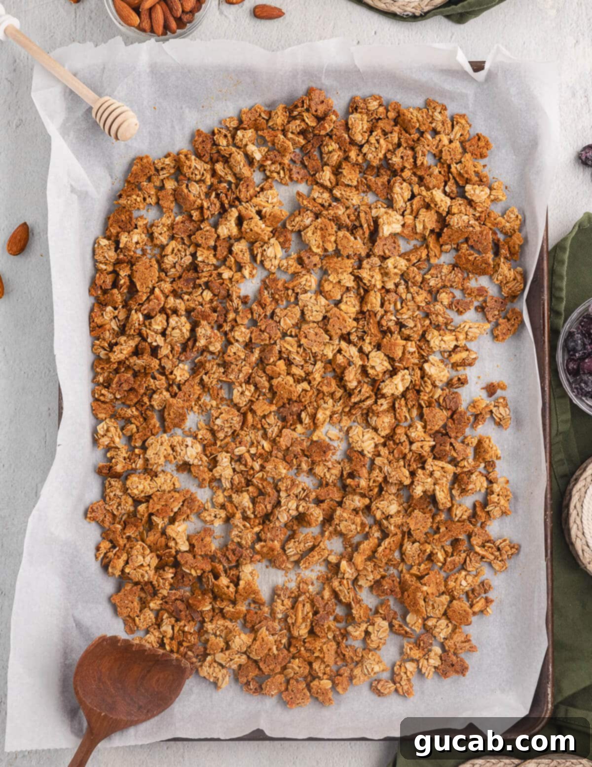 Almond Butter Crunch Granola 12 Almond butter granola clusters on a sheet pan, showcasing the crispy texture and large, satisfying clumps