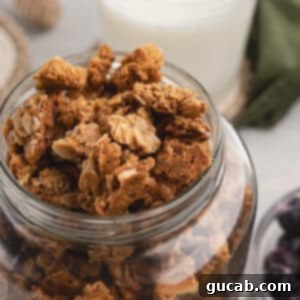 Almond Butter Crunch Granola 14 A glass jar filled with homemade almond butter granola, showcasing its crunchy texture and golden-brown color