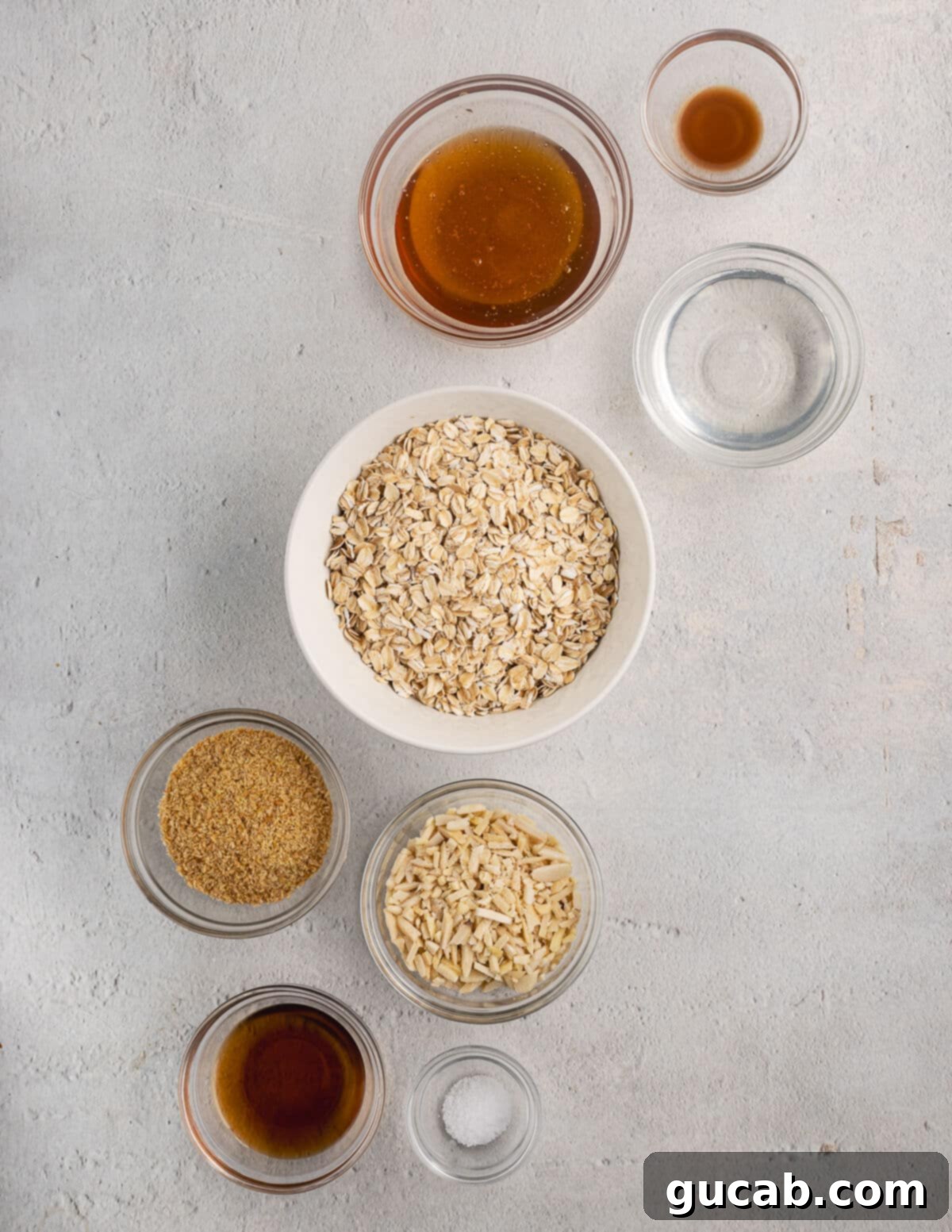 Almond Butter Crunch Granola 3 Close-up shot of key ingredients for almond butter granola: rolled oats, slivered almonds, flaxseed meal, almond butter, coconut oil, and maple syrup